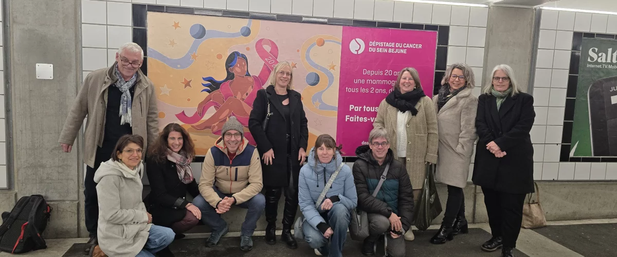 Légende : Les membres de l’ADC BEJUNE posent fièrement devant une affiche pour la promotion du dépistage du cancer du sein.