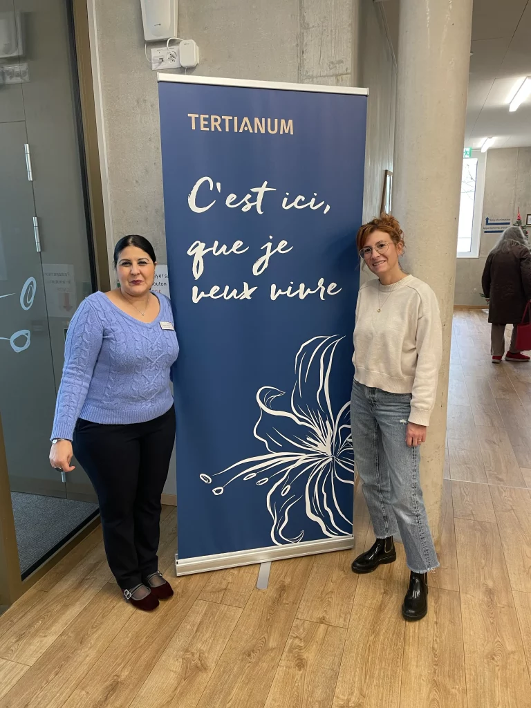 Légende : Rafika Teguig (à gauche), responsable communication de Tertianum Delémont, et Audrey Devilloni, fondatrice de la crèche Fil’harmonid posent à l’entrée du site La Sorne.