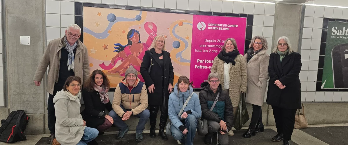 Les membres de l’ADC BEJUNE posent fièrement devant une affiche pour la promotion du dépistage du cancer du sein.