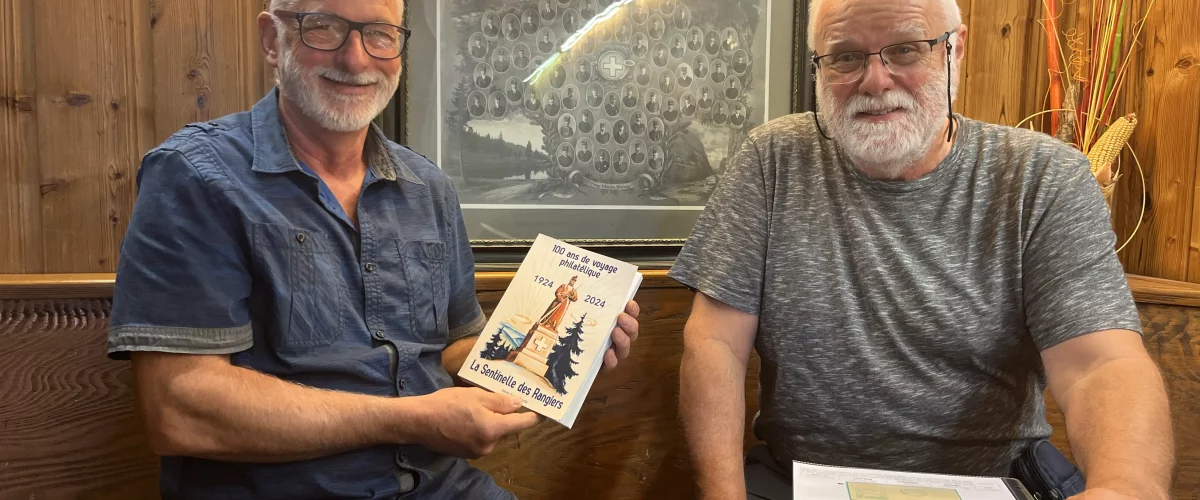Les deux collectionneurs posent avec des extraits de leurs travaux, devant une affiche ancienne de la société suisse des employés de poste.